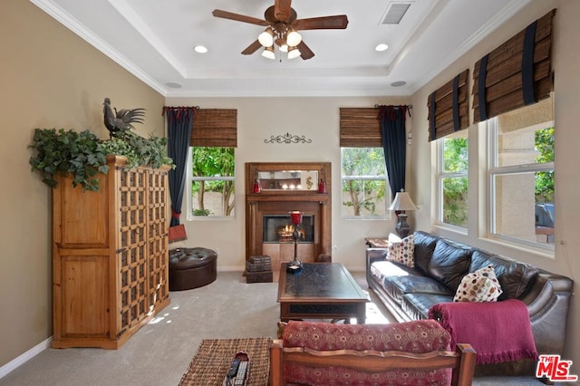 carpeted living room featuring a raised ceiling, crown molding, and ceiling fan