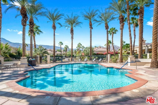 view of pool with a patio and a mountain view