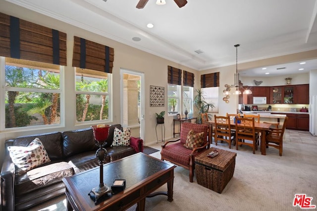 carpeted living room featuring ceiling fan with notable chandelier and crown molding