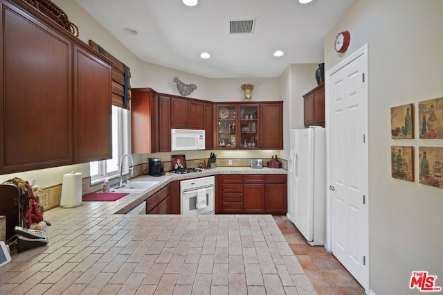 kitchen featuring kitchen peninsula, sink, and white appliances