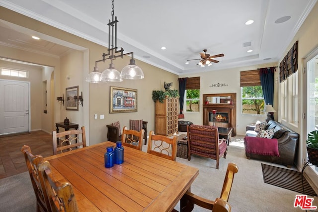 carpeted dining space with ornamental molding and ceiling fan