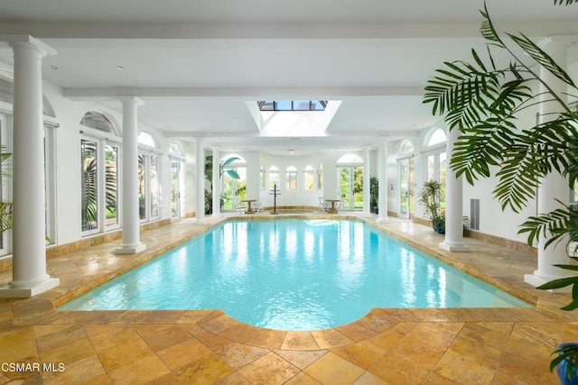 view of swimming pool with a skylight and ornate columns