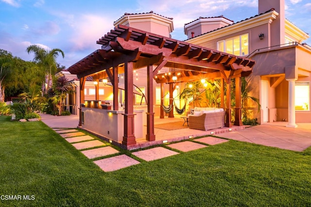 back house at dusk featuring an outdoor living space, a pergola, a patio area, and a lawn