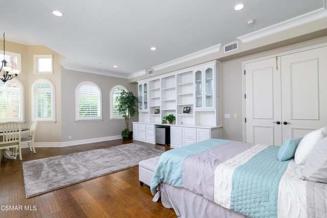 bedroom with crown molding, dark hardwood / wood-style flooring, a chandelier, and a closet