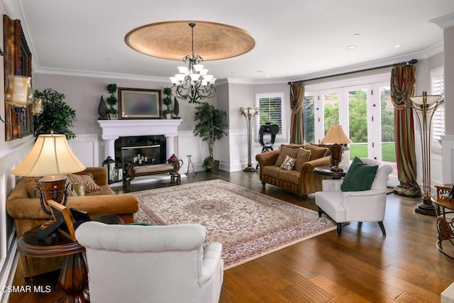 living room featuring crown molding, a healthy amount of sunlight, a fireplace, and dark wood-type flooring