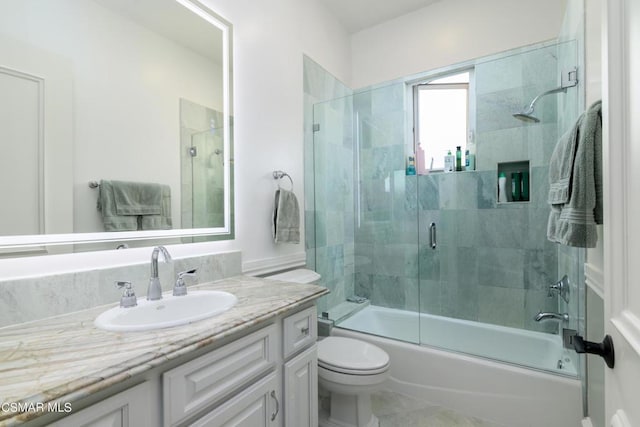 full bathroom featuring vanity, bath / shower combo with glass door, and toilet