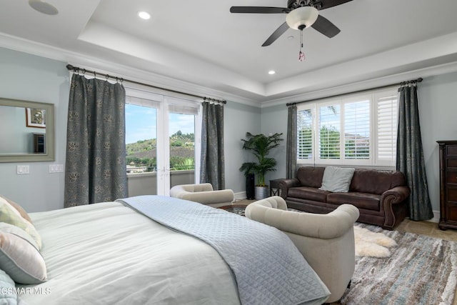 bedroom featuring crown molding, ceiling fan, a raised ceiling, and multiple windows