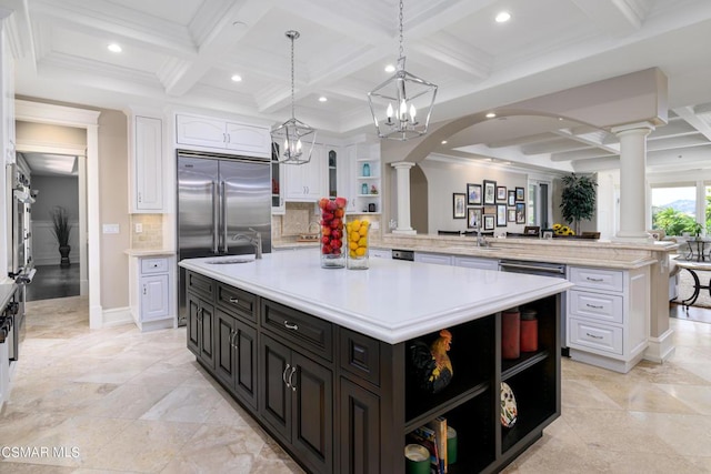 kitchen with white cabinetry, an island with sink, stainless steel built in fridge, and backsplash