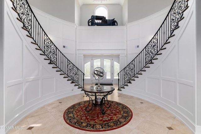 entryway featuring french doors, a wealth of natural light, and a high ceiling