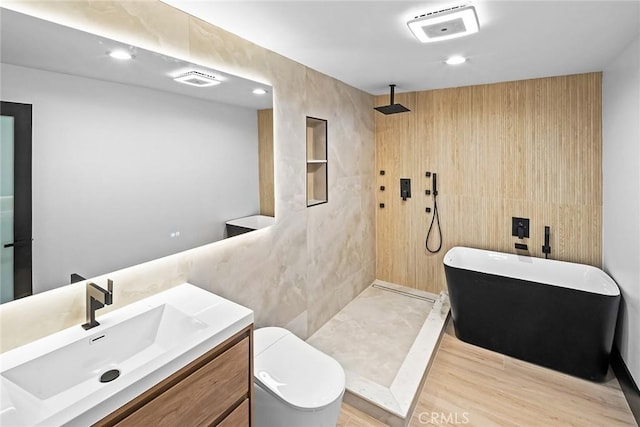 full bathroom featuring shower with separate bathtub, vanity, hardwood / wood-style flooring, and toilet