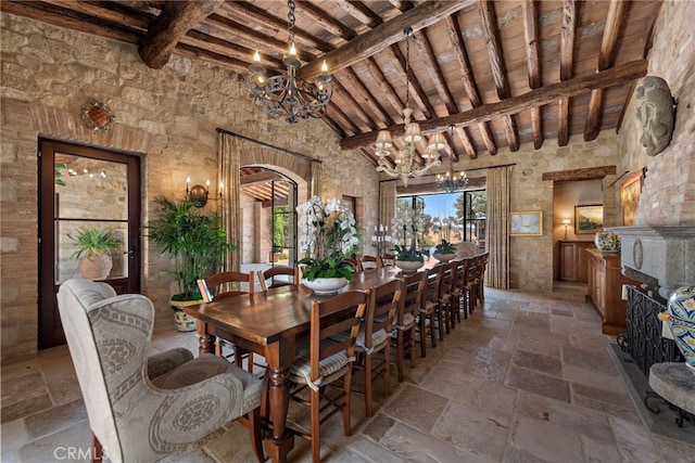 dining area featuring a towering ceiling, beamed ceiling, wood ceiling, and a notable chandelier