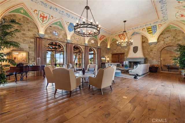 dining area featuring a notable chandelier, a fireplace, hardwood / wood-style floors, and ornamental molding