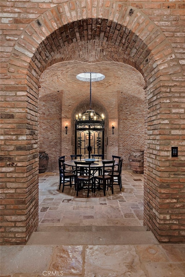 wine area with brick wall and a chandelier