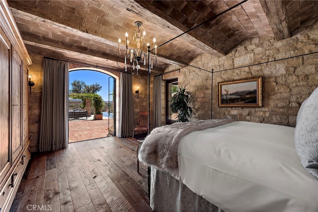 unfurnished bedroom with an inviting chandelier, brick ceiling, dark hardwood / wood-style floors, and access to outside