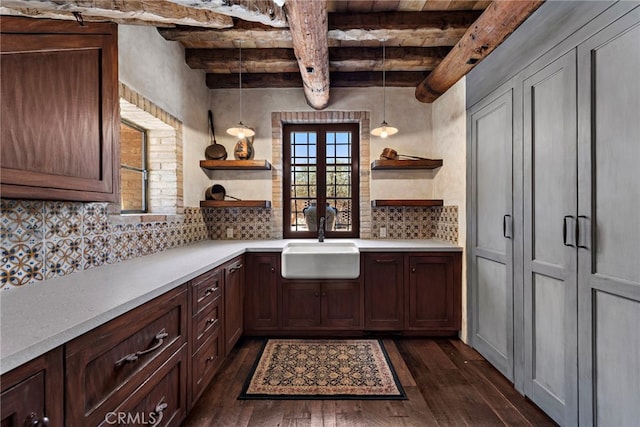 kitchen with decorative backsplash, dark hardwood / wood-style floors, sink, pendant lighting, and beam ceiling