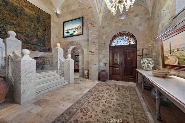 entrance foyer with high vaulted ceiling and a chandelier