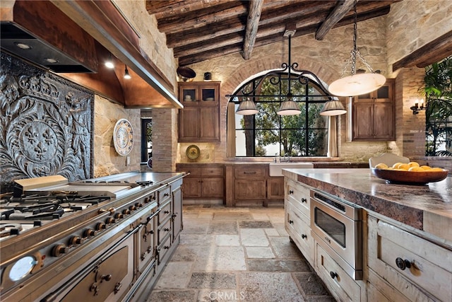 kitchen featuring high vaulted ceiling, appliances with stainless steel finishes, sink, and beam ceiling