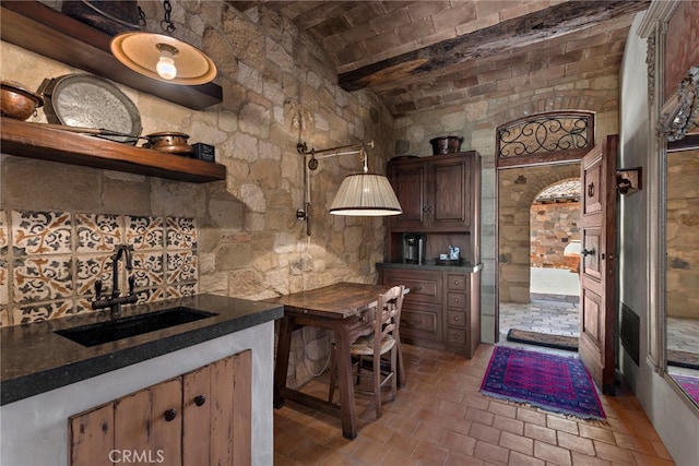 kitchen featuring brick ceiling and sink