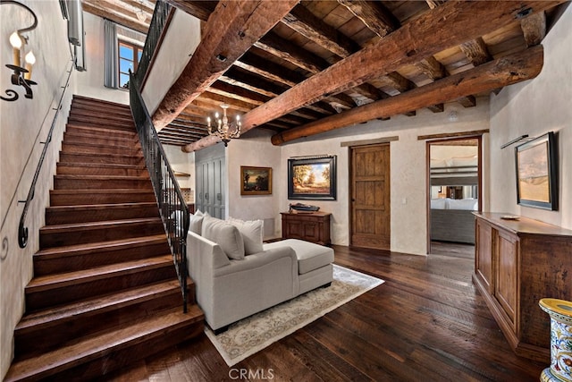 living room featuring dark wood-type flooring, beam ceiling, and an inviting chandelier