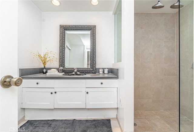 bathroom featuring a tile shower and vanity