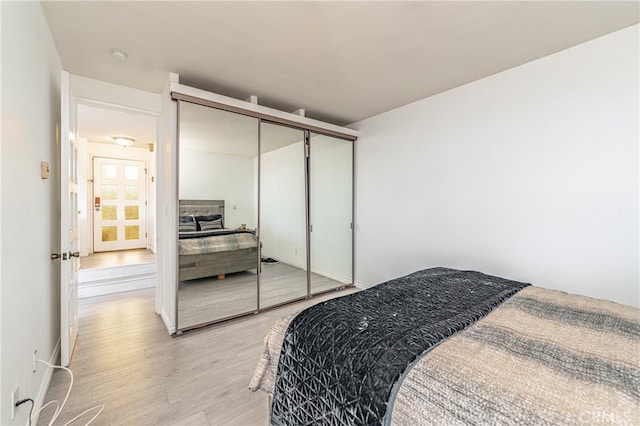 bedroom with light wood-type flooring and a closet