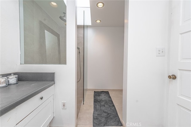 bathroom featuring walk in shower, vanity, and tile patterned flooring