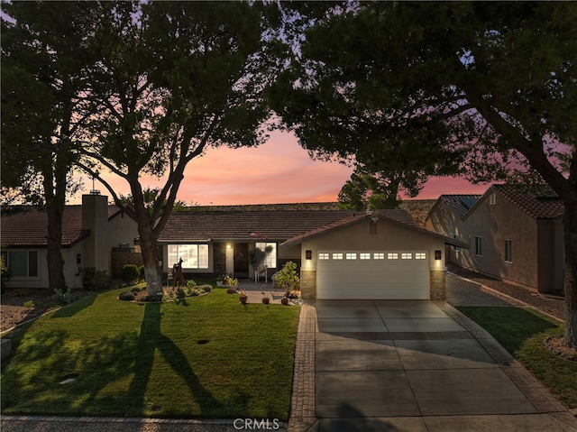 ranch-style house with a garage and a lawn