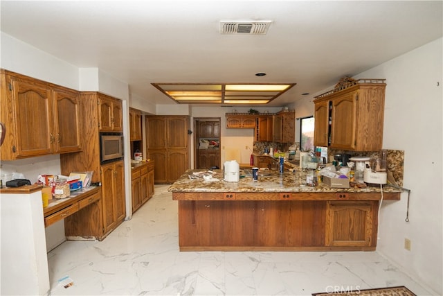 kitchen with dark stone countertops and kitchen peninsula