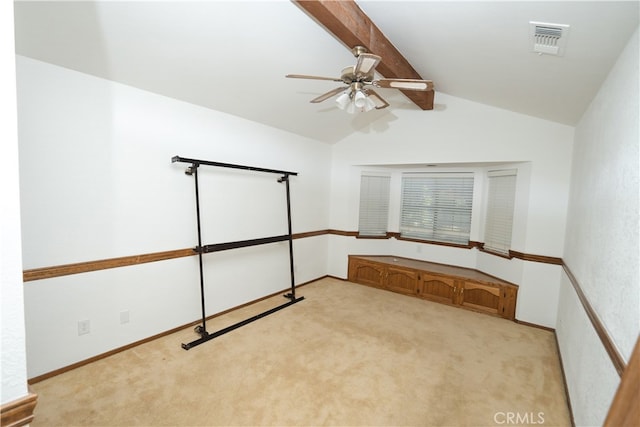 carpeted empty room featuring vaulted ceiling with beams and ceiling fan