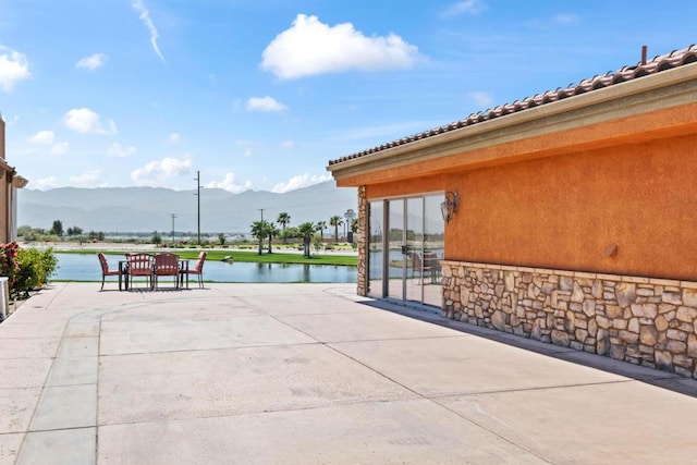 surrounding community featuring a patio area and a water and mountain view