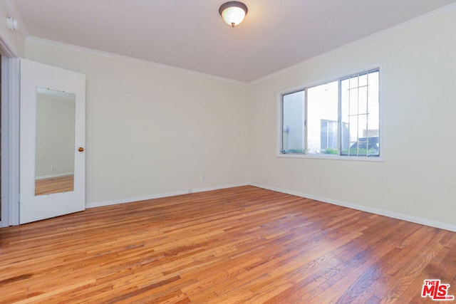 empty room with light hardwood / wood-style floors and crown molding