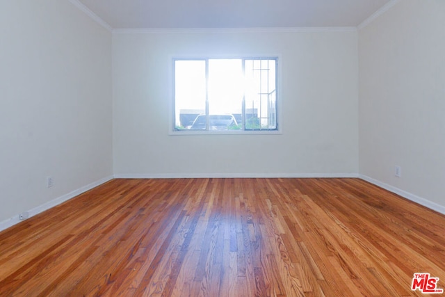 unfurnished room featuring ornamental molding and light hardwood / wood-style flooring