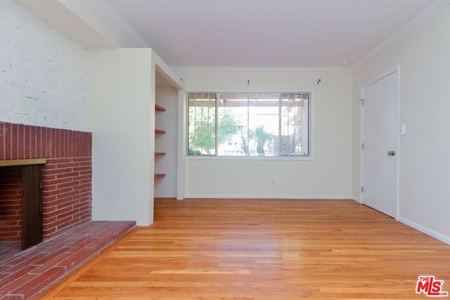 unfurnished living room featuring crown molding, light hardwood / wood-style floors, and a brick fireplace