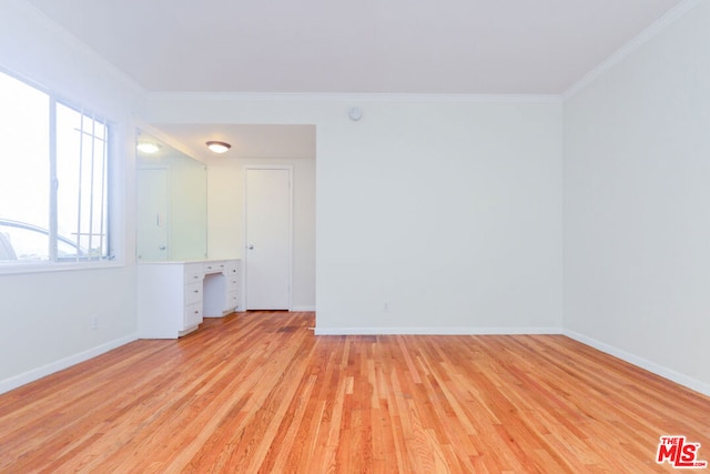 spare room with ornamental molding and light hardwood / wood-style flooring