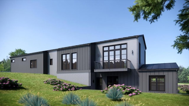 rear view of house with a lawn and a balcony