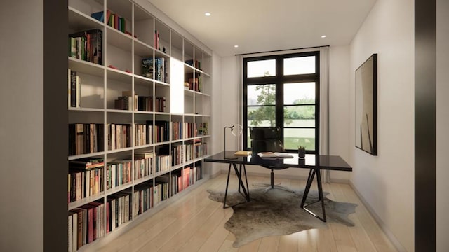 office area with light hardwood / wood-style floors and a wall of windows