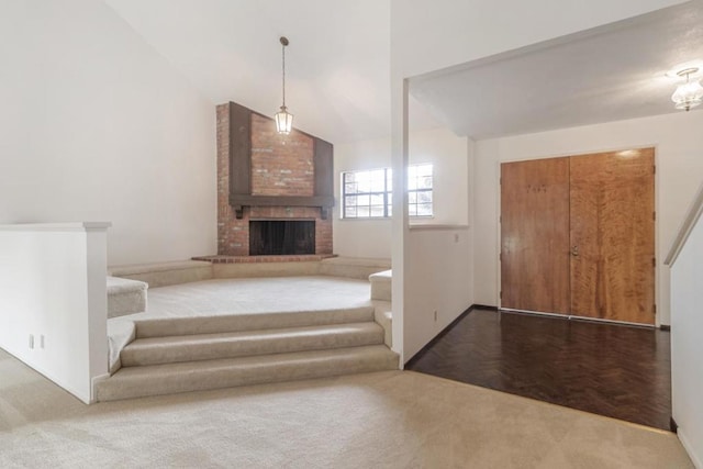 stairs with a brick fireplace and high vaulted ceiling