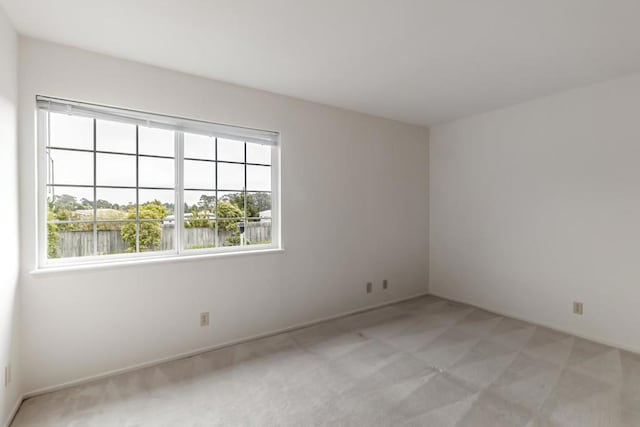 empty room featuring light carpet and a water view