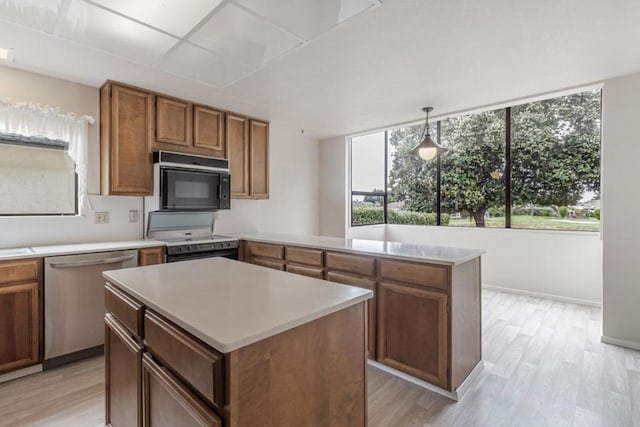 kitchen with a kitchen island, pendant lighting, light hardwood / wood-style floors, and black appliances