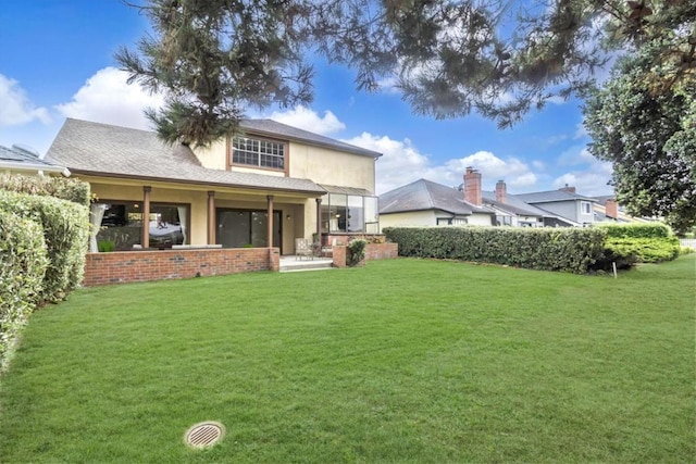 rear view of house featuring a yard