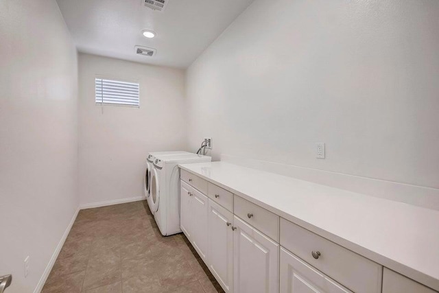 clothes washing area with cabinets and washing machine and dryer