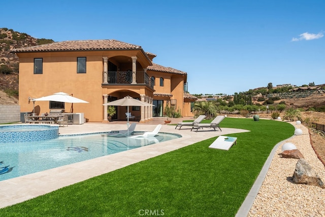 view of pool featuring a lawn and a patio