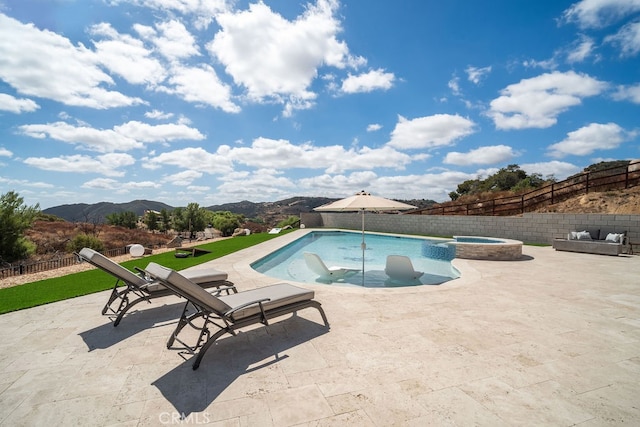 view of swimming pool with a mountain view, an in ground hot tub, and a patio