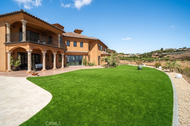 view of yard featuring a patio and a balcony