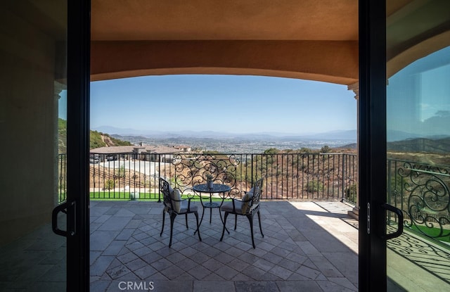 view of patio / terrace featuring a mountain view and a balcony