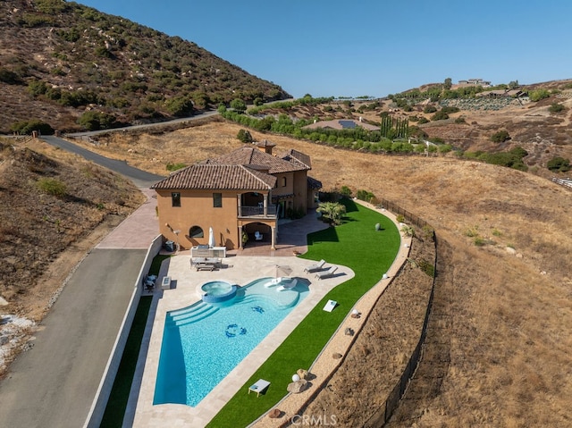 view of swimming pool with a patio, an in ground hot tub, and a mountain view