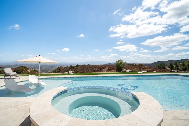 view of swimming pool with a mountain view, a diving board, an in ground hot tub, and a patio area