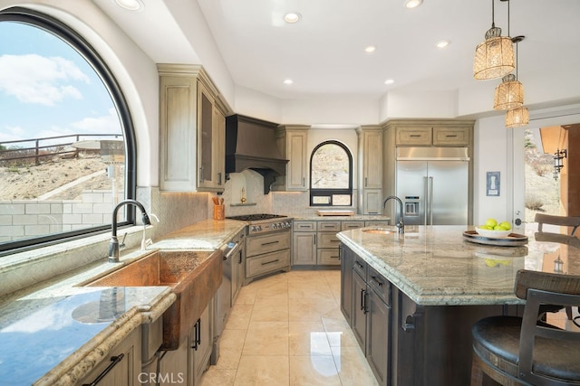 kitchen featuring decorative backsplash, appliances with stainless steel finishes, pendant lighting, and a healthy amount of sunlight