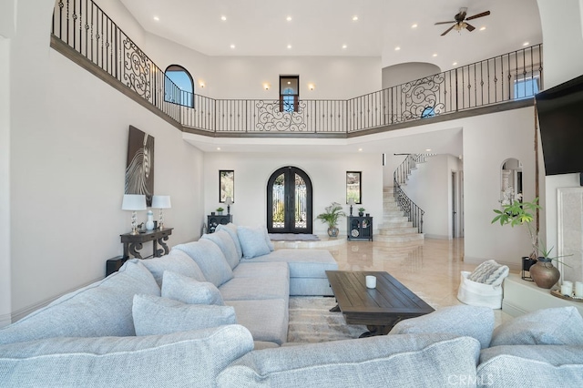 living room featuring a high ceiling and ceiling fan