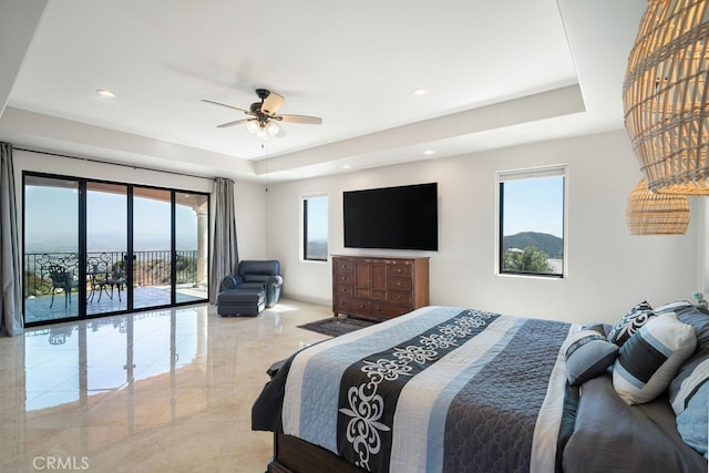 bedroom with ceiling fan, a raised ceiling, and access to exterior